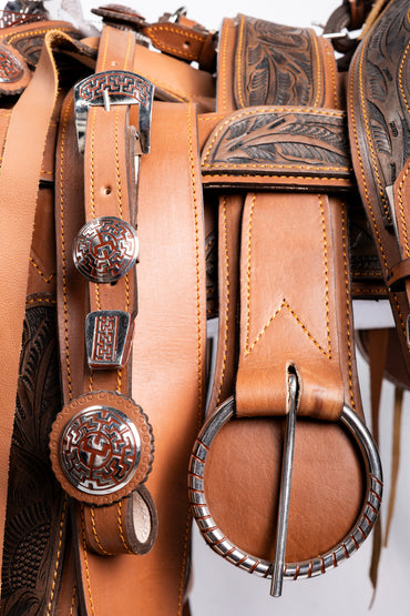 MONTURA COLA DE PATO CON CANTINA GUARDA CINCELADAS TABACO CON FUSTE Y HERRAJE EN ACERO CON FONDO CAFÉ